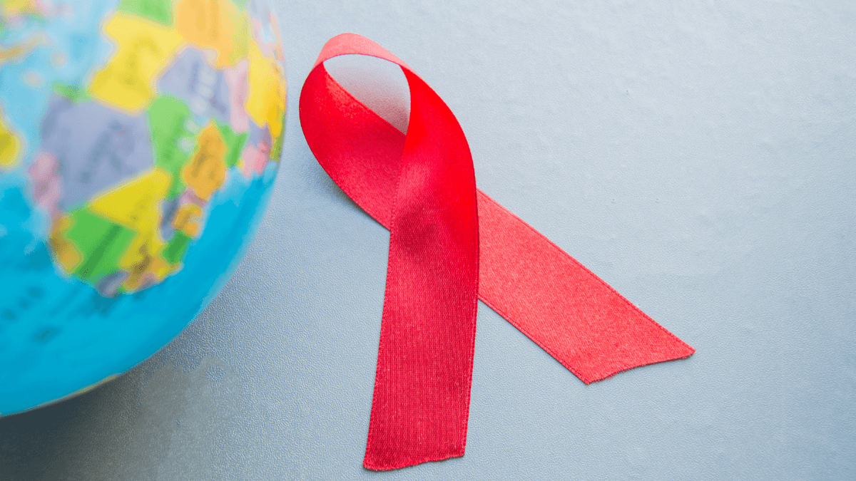 Red HIV awareness ribbon beside a globe